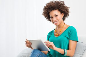 Portrait Of Young Happy African Woman Using Digital Tablet